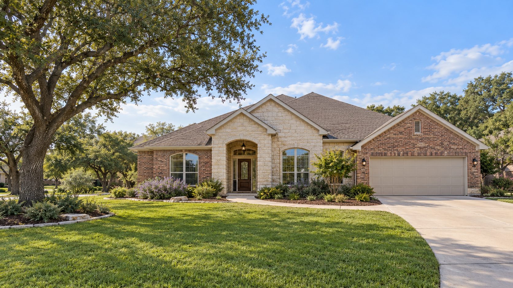 Well-kept limestone and brick ranch home with tidy front beds and a mature live oak